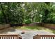 View of the backyard featuring a privacy fence, fire pit, grass, and mature trees at 1218 Crestwood Se Dr, Atlanta, GA 30316