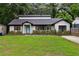 Charming single-story home with manicured lawn, flowerbeds, and a bright blue front door at 1218 Crestwood Se Dr, Atlanta, GA 30316