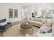 Sun-filled living room with sectional sofa adjacent to kitchen area, offering ample space for relaxation and entertainment at 309 Brooke View Trail, Canton, GA 30115