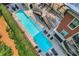 Aerial view of swimming pool with lounge chairs, patio area, and building with manicured shrubs and trees at 560 Dutch Valley Road # 2412, Atlanta, GA 30324
