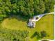 Aerial view of a home surrounded by lush greenery, a private pool, and a winding driveway at 692 Brooks Woolsey Rd, Brooks, GA 30205