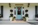 Close-up of the charming front porch featuring a blue door, potted plants, and inviting decor at 692 Brooks Woolsey Rd, Brooks, GA 30205