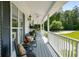Relaxing front porch area with comfortable seating, decorative plants, and a picturesque view of the lush landscape at 692 Brooks Woolsey Rd, Brooks, GA 30205