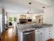 Kitchen with stainless appliances, granite counters, white cabinets and views to the living area at 692 Brooks Woolsey Rd, Brooks, GA 30205