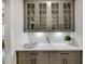 Charming bar area features glass-front cabinets and marble countertops, perfect for entertaining at 782 Brooke View Drive, Canton, GA 30115
