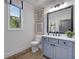 Charming bathroom with a gray vanity, framed mirror, and a window with a view of the wooded outdoors at 782 Brooke View Drive, Canton, GA 30115