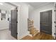 Hallway featuring hardwood floors, gray doors, and staircase to the upper level at 782 Brooke View Drive, Canton, GA 30115