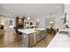 Open-concept kitchen featuring an island with seating, stainless steel appliances, and views of the living area and fireplace at 782 Brooke View Drive, Canton, GA 30115
