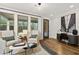 Inviting living room featuring large windows, comfortable seating, and a stylish workspace, all contributing to a cozy atmosphere at 782 Brooke View Drive, Canton, GA 30115
