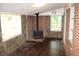 Cozy living room with a brick fireplace, wood-look floors, and abundant natural light at 8469 Shiloh Ct, Jonesboro, GA 30238