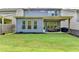 Inviting backyard with an expansive lawn, gray siding, covered patio, string lights, and outdoor furniture at 1045 Penny Ln, Roswell, GA 30076