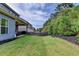 Large backyard with a lush lawn, side house view, landscaping, and a wooden privacy fence at 1045 Penny Ln, Roswell, GA 30076