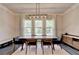 Bright dining room with large windows, modern chandelier, and sleek wooden table set at 1045 Penny Ln, Roswell, GA 30076
