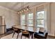 Dining room with modern lighting and wooden table near large windows with natural light at 1045 Penny Ln, Roswell, GA 30076