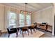Dining room with a wooden table, six chairs, large windows and modern light fixture at 1045 Penny Ln, Roswell, GA 30076