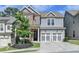 Beautiful two-story home with gray siding, brick accents, a manicured lawn, and an attached two-car garage at 1045 Penny Ln, Roswell, GA 30076