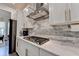 Beautiful kitchen features white cabinets, modern countertops, a gas cooktop and stainless range hood at 1045 Penny Ln, Roswell, GA 30076