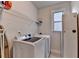 Bright laundry room featuring modern washer and dryer, shelving, and natural light from a window at 1045 Penny Ln, Roswell, GA 30076