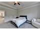 A main bedroom with tray ceilings, neutral carpet, and a white couch near the window at 1045 Penny Ln, Roswell, GA 30076
