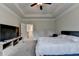 Bright main bedroom featuring tray ceilings, neutral carpet, and a television at 1045 Penny Ln, Roswell, GA 30076