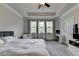 Comfortable main bedroom with tray ceilings, lots of windows, and a ceiling fan at 1045 Penny Ln, Roswell, GA 30076