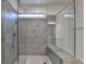 Modern tiled shower with glass doors and bench seating, illuminated by a small window at 1045 Penny Ln, Roswell, GA 30076