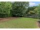 Spacious backyard with green lawn and mature trees, offering a serene and private outdoor space at 2737 Fontainebleau Drive, Dunwoody, GA 30360