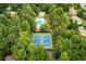 Aerial view of tennis courts and community pool nestled in a lush, wooded neighborhood at 2737 Fontainebleau Drive, Dunwoody, GA 30360