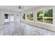Bright sunroom featuring tiled floors, large windows providing natural light, and a sliding door to access backyard at 2737 Fontainebleau Drive, Dunwoody, GA 30360