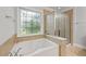Bathroom featuring decorative window, tub with chrome fixtures and glass-enclosed shower at 2873 Overlook Ne Way, Atlanta, GA 30324
