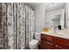 This bathroom features a patterned shower curtain, a toilet and vanity with cherry wood cabinets at 2873 Overlook Ne Way, Atlanta, GA 30324