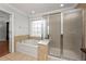 Bathroom featuring decorative window, tub with chrome fixtures and glass-enclosed shower at 2873 Overlook Ne Way, Atlanta, GA 30324