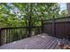 Relax outdoors on this wooden deck surrounded by a dark railing and lush green trees at 2873 Overlook Ne Way, Atlanta, GA 30324