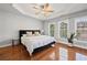 Primary bedroom with tray ceiling, ceiling fan, wood floors, and bright windows at 2873 Overlook Ne Way, Atlanta, GA 30324