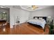 Primary bedroom with tray ceiling, ceiling fan, wood floors, and bright windows at 2873 Overlook Ne Way, Atlanta, GA 30324