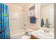 Bathroom features a tub-shower combo with a shower curtain and cabinet with counter and basin sink at 45 Ratliff Dr, Covington, GA 30016