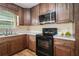 Well-lit kitchen features warm wood cabinets, white countertops, a black range, and a stainless steel microwave at 45 Ratliff Dr, Covington, GA 30016