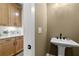 Powder room featuring custom cabinets with light countertop and a decorative pedestal sink at 604 Southland Pass, Canton, GA 30115