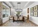 Bright dining room with modern chandelier, wood table, four chairs, and decorative window at 604 Southland Pass, Canton, GA 30115