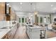 Open-concept kitchen with white island, long countertops, wooden cabinets, stainless appliances, and hardwood floors at 604 Southland Pass, Canton, GA 30115