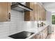Well-equipped kitchen features tile backsplash, custom hood, and modern electric cooktop at 604 Southland Pass, Canton, GA 30115