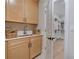 Bright laundry room features a sink, wooden cabinets, quartz countertop, and a door to the walk-in closet at 604 Southland Pass, Canton, GA 30115