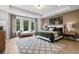 Serene main bedroom with large windows, tray ceiling, and a cozy sitting area for relaxing at 604 Southland Pass, Canton, GA 30115