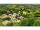 Aerial view of a neighborhood featuring multiple homes and lots of trees, some adjacent to golf course at 908 Basingstoke Ct, Suwanee, GA 30024