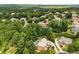 Aerial view of a neighborhood featuring multiple houses and lush trees, some homes with swimming pools at 908 Basingstoke Ct, Suwanee, GA 30024