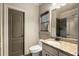 Bathroom featuring granite countertops, a toilet, a tiled shower, a window with blinds, and a door at 908 Basingstoke Ct, Suwanee, GA 30024