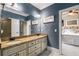 Bathroom with a granite countertop, double sinks, gray walls, and a view into a bedroom at 908 Basingstoke Ct, Suwanee, GA 30024
