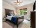 Comfortable bedroom with a dark wood bed frame, ceiling fan, and natural light at 908 Basingstoke Ct, Suwanee, GA 30024