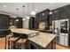 Charming kitchen features dark cabinets, pendant lights, stainless steel appliances, and a tiled backsplash at 908 Basingstoke Ct, Suwanee, GA 30024