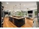 Open concept kitchen flows to the living room, features an island, stainless steel appliances, and hardwood floors at 908 Basingstoke Ct, Suwanee, GA 30024